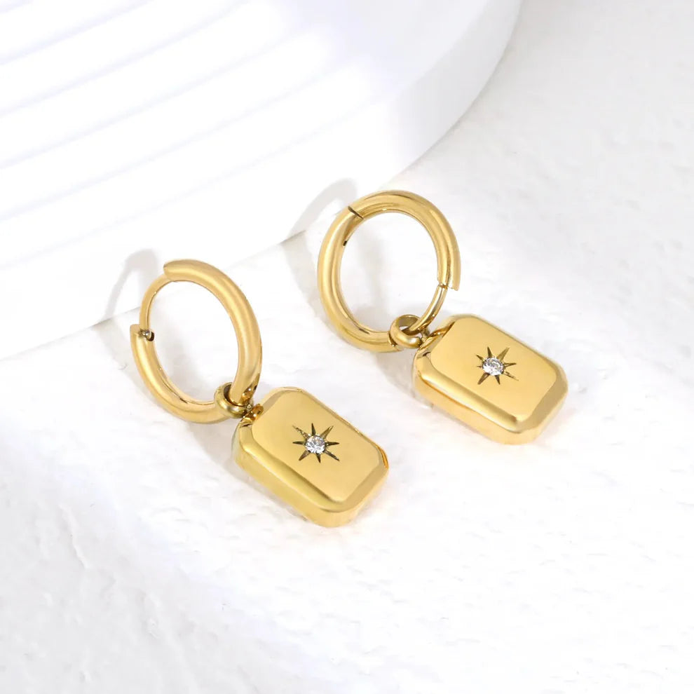 Elegante oorringen met een achtpuntige ster, versierd met sprankelende witte strass-steentjes. De rechthoekige sterhanger meet 9,3 × 12,4 mm en hangt aan een binnenring van 2,0 × 10 mm, wat zorgt voor een evenwichtig en opvallend silhouet. Deze oorbellen zijn gemaakt van hypoallergeen roestvrij staal met een 18K gouden plating, waardoor ze zacht zijn voor de gevoelige huid en bestand zijn tegen verkleuring. Met een gewicht van slechts 5 gram per paar zijn ze licht en comfortabel om de hele dag te dragen. Pe